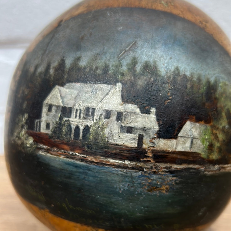 Painted coconut with a house near the water