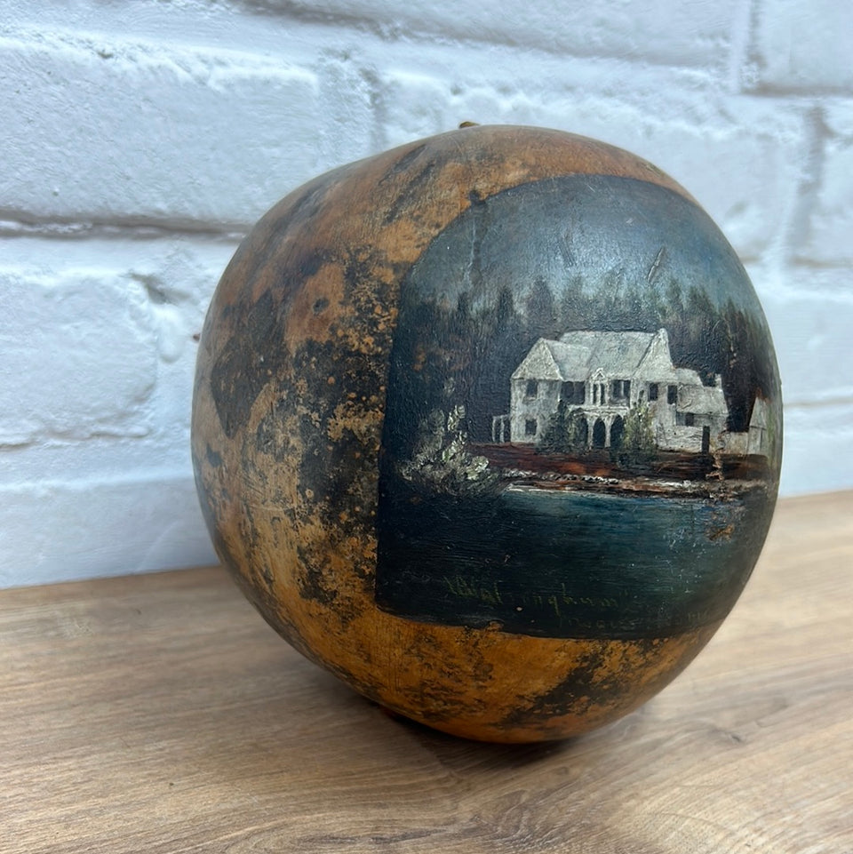 Painted coconut with a house near the water