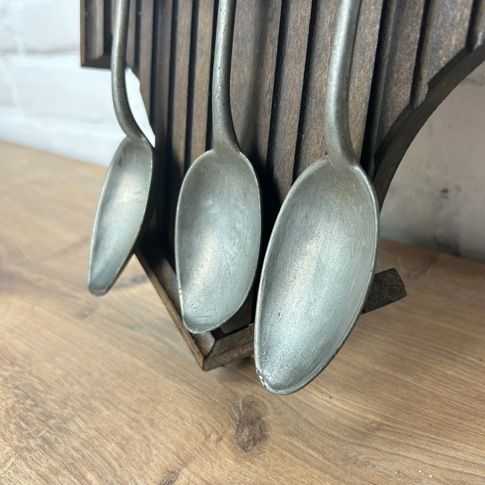 Antique wooden wall display with 6 old tin spoons.