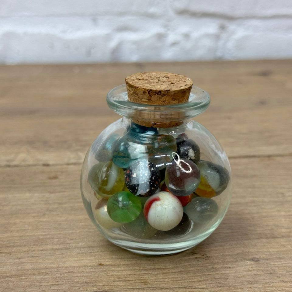 A miniature jar with mixed antique and vintage peewee mini marbles