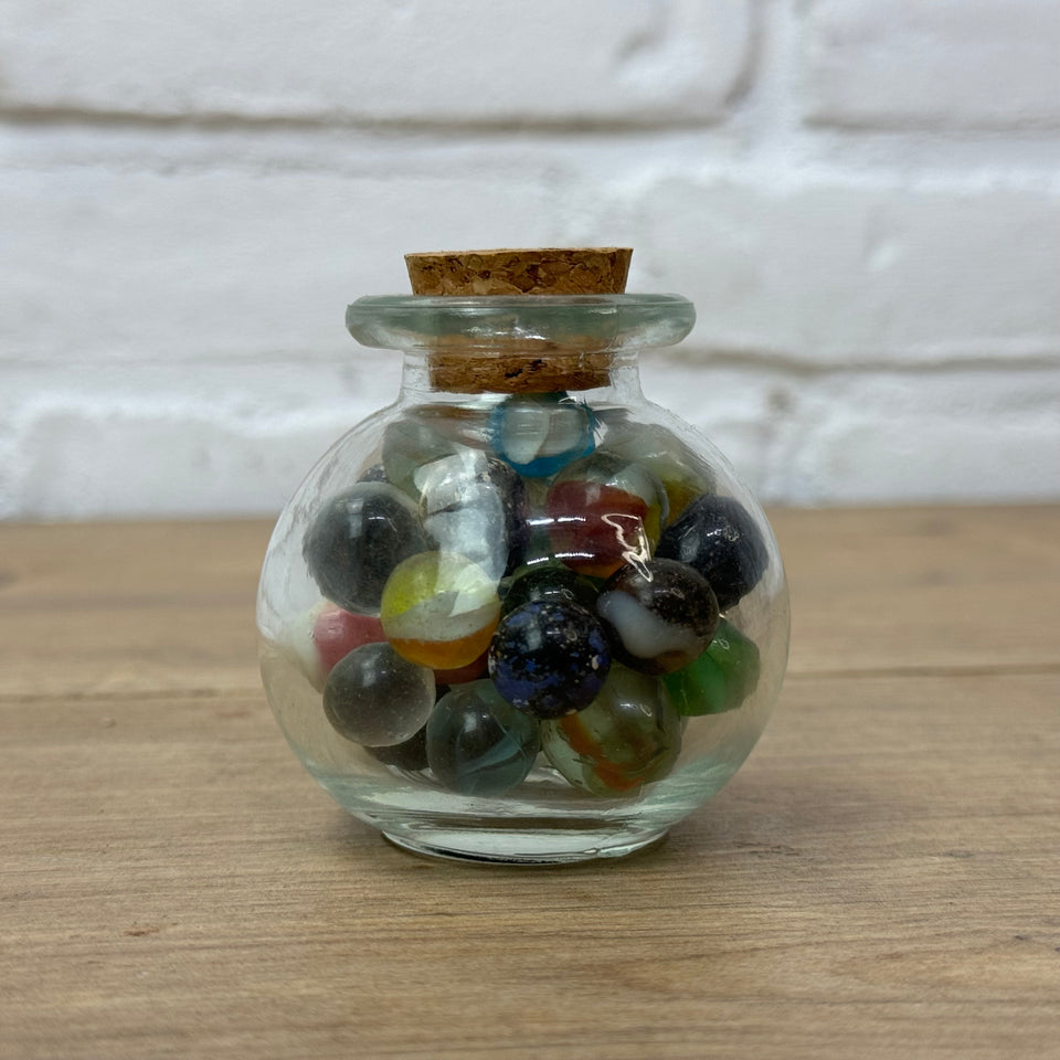 A miniature jar with mixed antique and vintage peewee mini marbles