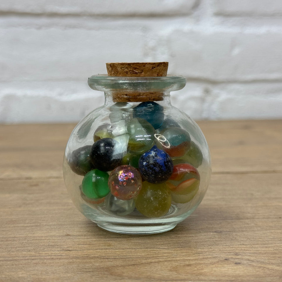 A miniature jar with mixed antique and vintage peewee mini marbles