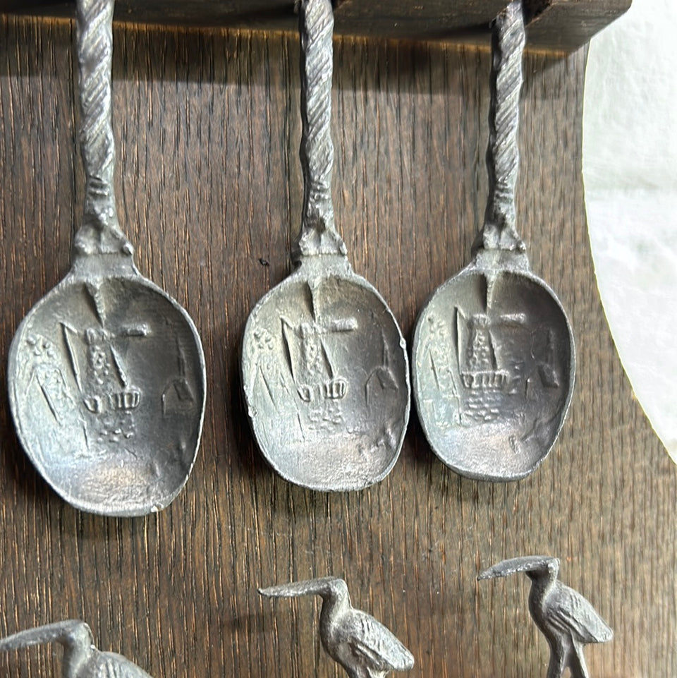 Antique wooden wall hanging with 6 old small Dutch tin spoons.