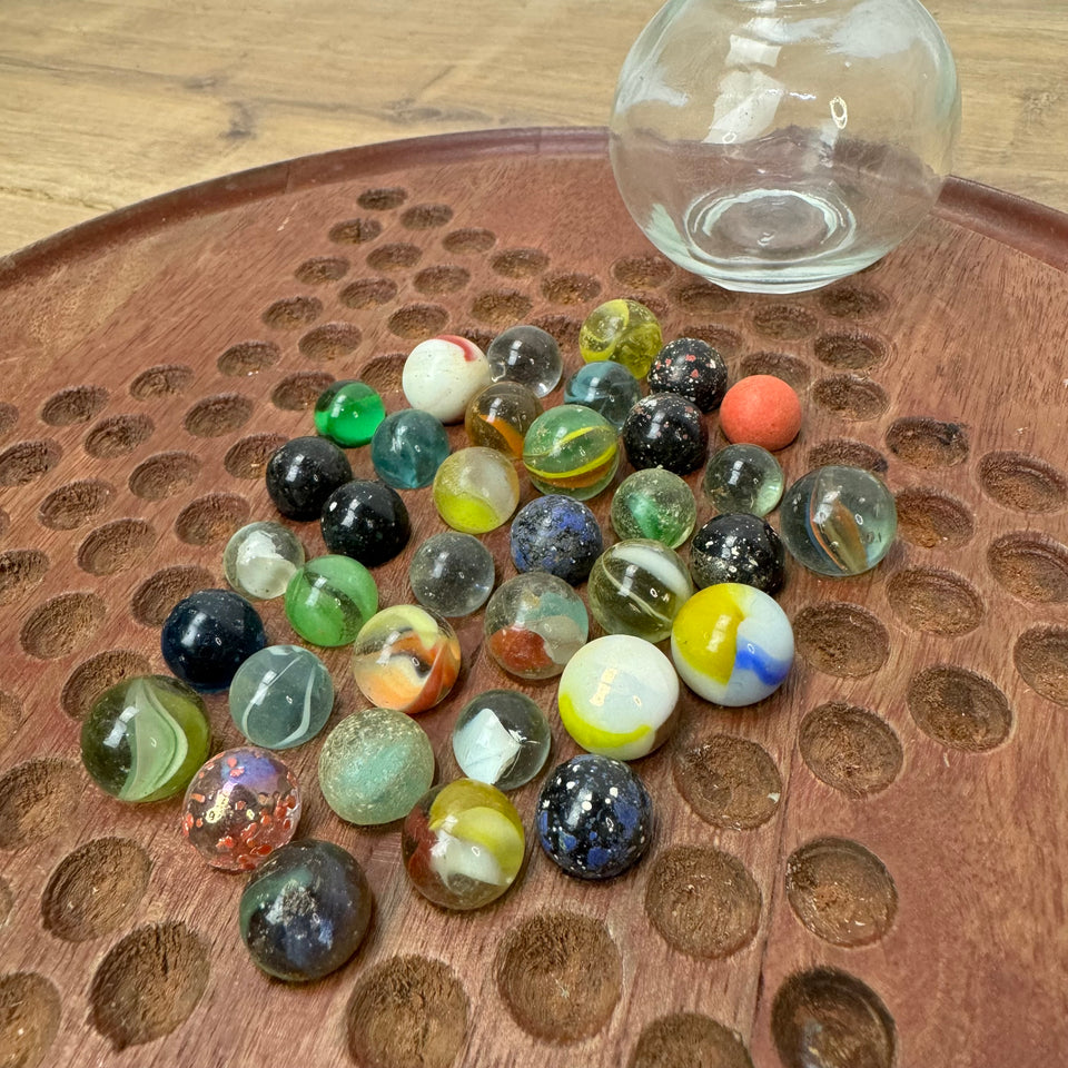 A miniature jar with mixed antique and vintage peewee mini marbles