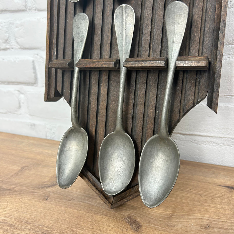 Antique wooden wall display with 6 old tin spoons.