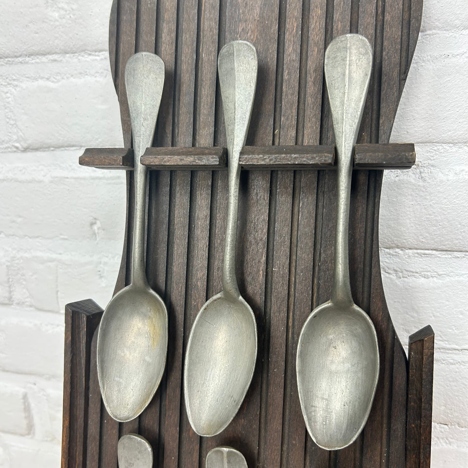 Antique wooden wall display with 6 old tin spoons.