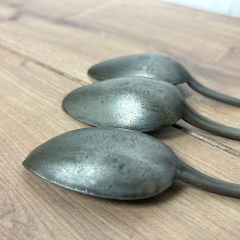 Antique wooden wall display with 6 old tin spoons.