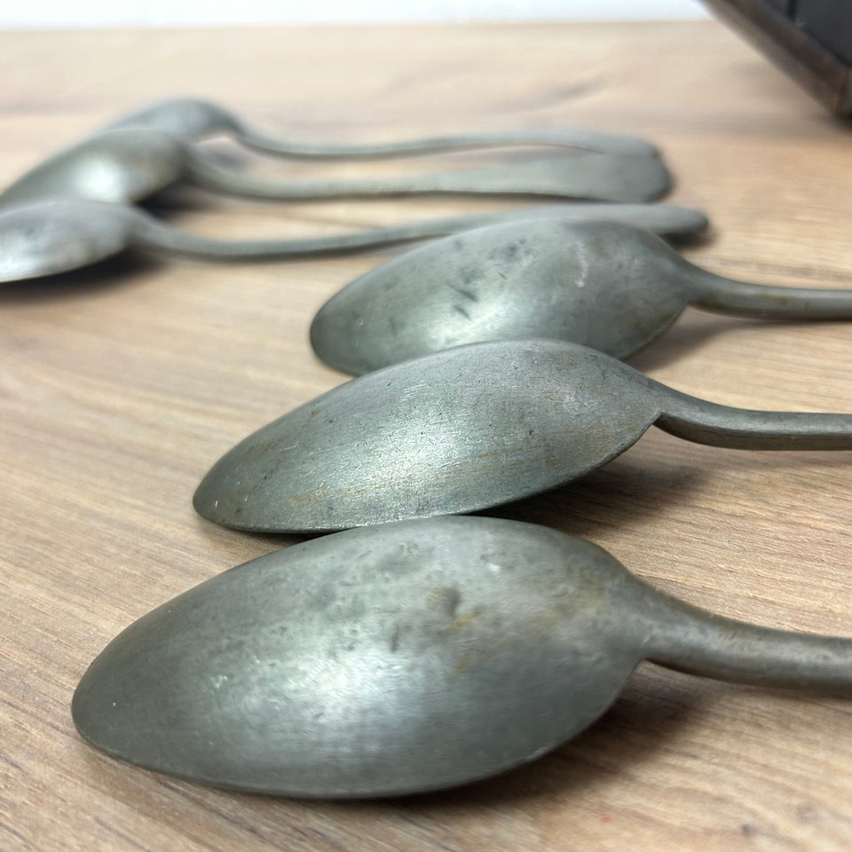 Antique wooden wall display with 6 old tin spoons.