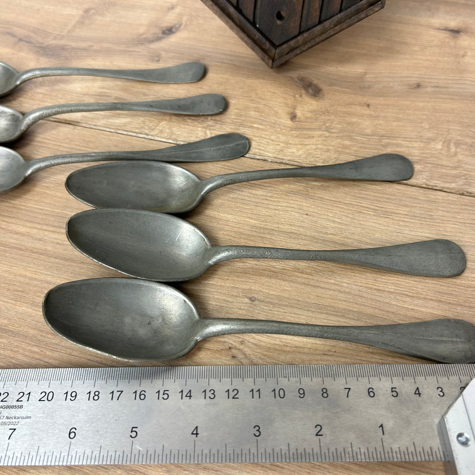 Antique wooden wall display with 6 old tin spoons.