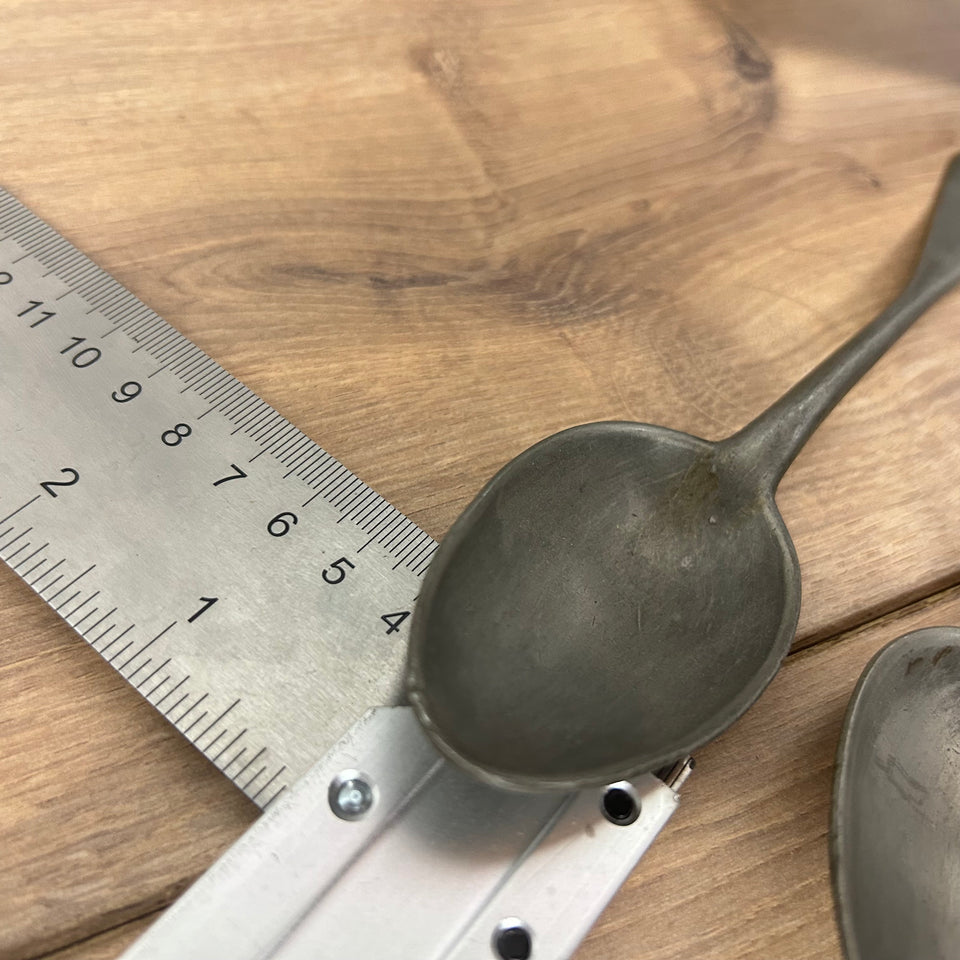 Antique wooden wall display with 6 old tin spoons.